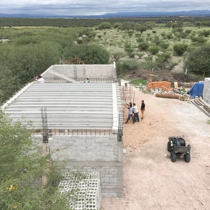 Building works on the ranch seen from above, an off-road vehicle beside them.